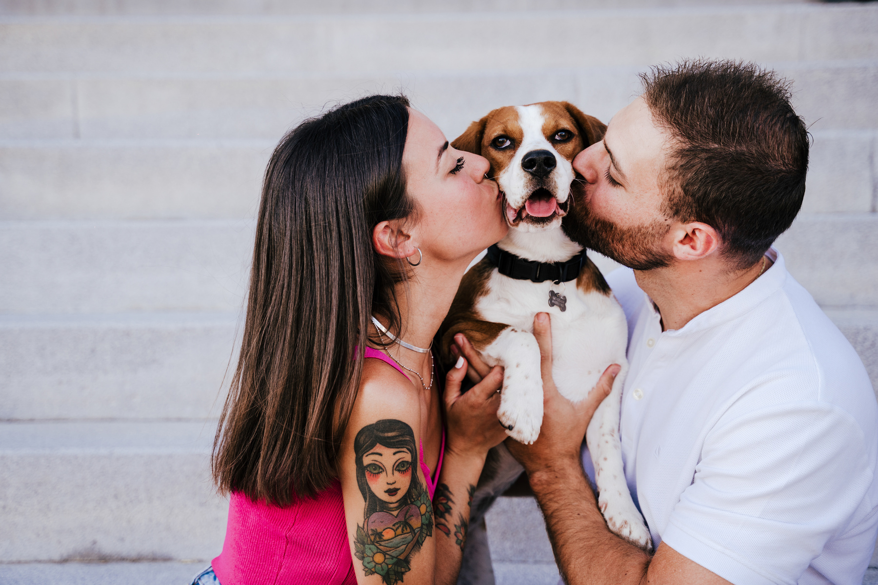 Young Couple Kissing Their Dog